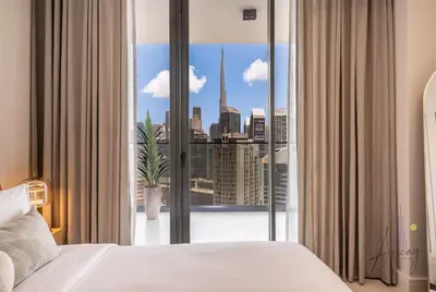 a bedroom with a large window with a view of a city at Burj Khalifa View Luxe 1BR Paragon by IGO in Dubai