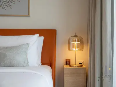 a bedroom with a bed and a lamp on a night stand at Burj Khalifa View Luxe 1BR Paragon by IGO in Dubai