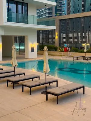 a swimming pool with chaise lounges in a building at Burj Khalifa View Luxe 1BR Paragon by IGO in Dubai