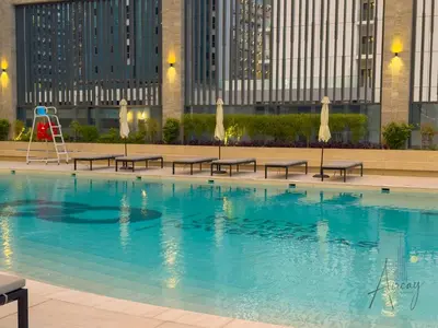 a swimming pool with benches and a playground at Burj Khalifa View Luxe 1BR Paragon by IGO in Dubai