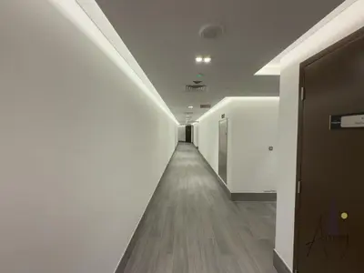 a long hallway with white walls and wood floors at Burj Khalifa View Luxe 1BR Paragon by IGO in Dubai