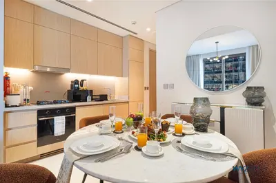 a kitchen with a table with plates and glasses of orange juice at Ritz 1BR Vida Dubai Mall Hotel Amenity & Mall Access in Dubai