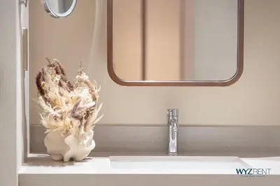 a vase sitting on a bathroom sink with a mirror at Ritz 1BR Vida Dubai Mall Hotel Amenity & Mall Access in Dubai