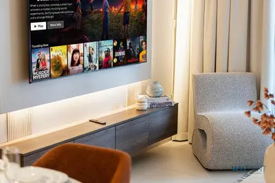 a living room with a tv and a chair at Ritz 1BR Vida Dubai Mall Hotel Amenity & Mall Access in Dubai