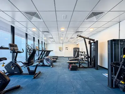 a gym with several treadmills and cardio machines at Cozy 1BR Apartment, 20 Min to Jebel Ali Beach in Dubai