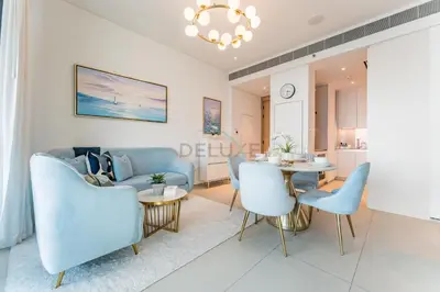 a living room with a table and blue chairs at Direct Beachfront Access, Connected to Address Beach Resort, Unmatched Walkability Near Cafes, Restaurants and Retail shops - Jumeirah Gate Tower, JBR by Deluxe Holiday Homes in Dubai