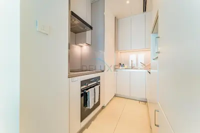 a kitchen with white cabinets and a stove at Direct Beachfront Access, Connected to Address Beach Resort, Unmatched Walkability Near Cafes, Restaurants and Retail shops - Jumeirah Gate Tower, JBR by Deluxe Holiday Homes in Dubai