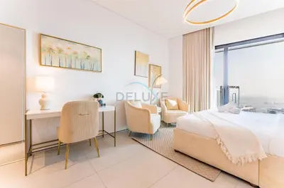 a bedroom with a bed and a desk and chairs at Direct Beachfront Access, Connected to Address Beach Resort, Unmatched Walkability Near Cafes, Restaurants and Retail shops - Jumeirah Gate Tower, JBR by Deluxe Holiday Homes in Dubai