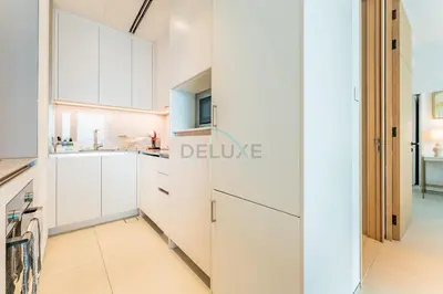 a white kitchen with white cabinets and a dishwasher at Direct Beachfront Access, Connected to Address Beach Resort, Unmatched Walkability Near Cafes, Restaurants and Retail shops - Jumeirah Gate Tower, JBR by Deluxe Holiday Homes in Dubai