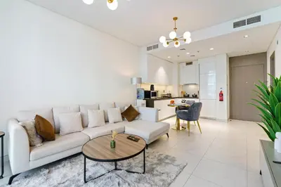 a living room with a white couch and a table at Cozy 1BR at D1 Residence 13 with Stunning City View in Dubai