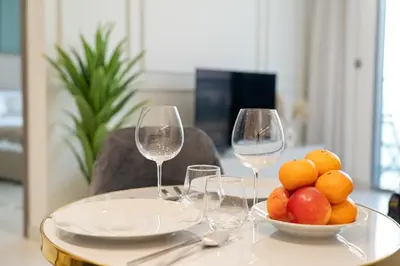 a table with wine glasses and a bowl of fruit at Cozy 1BR at D1 Residence 13 with Stunning City View in Dubai