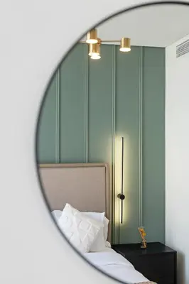 a mirror reflection of a bedroom with a bed at Cozy 1BR at D1 Residence 13 with Stunning City View in Dubai