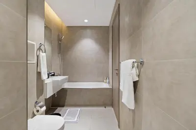 a bathroom with a toilet and a bath tub at Cozy 1BR at D1 Residence 13 with Stunning City View in Dubai