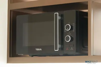 a microwave oven sitting on top of a shelf at Posh 2BR Vida Dubai Mall Hotel Amenity & Mall Access in Dubai