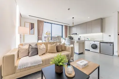 a living room with a couch and a kitchen at Minutes from City Walk, Downtown Dubai and Jumeirah Beach, Easy Access to Metro Stations and Major Roads - Arista One, Al Satwa by Deluxe Holiday Homes in Dubai