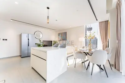 a white kitchen and dining room with a table and chairs at Minutes from City Walk, Downtown Dubai and Jumeirah Beach, Easy Access to Metro Stations and Major Roads - Arista One, Al Satwa by Deluxe Holiday Homes in Dubai