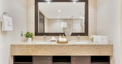 a bathroom with two sinks and a large mirror at 1BR Apartment Anantara Palm Private Beach in Dubai
