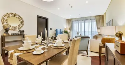 a dining room and living room with a table and chairs at 1BR Apartment Anantara Palm Private Beach in Dubai