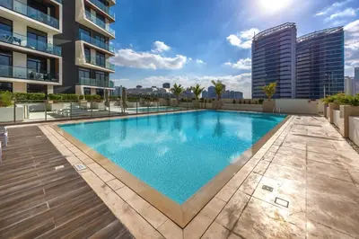 a swimming pool on the roof of a building at Stylish JVC Apt with Pool & Gym in Sabkhah