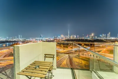 a chair on a balcony with a view of a city at Full Burj Khalifa and Dubai Canal views, Minutes from Downtown and Dubai Mall - Farhad Azizi Residence, Al Jaddaf by Deluxe Holiday Homes in Dubai