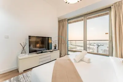 a white bedroom with a large bed and a large window at 3BR with Sea View, Short Stroll From Marina Walk and JBR Beach, With Easy Access to Tram and Metro - Ocean Heights, Dubai Marina by Deluxe Holiday Homes in Dubai