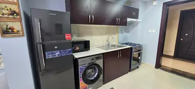 a kitchen with a washer and a sink and a refrigerator at Peaceful Apartments in Dubai