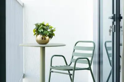 a table with a chair and a potted plant on it at Luxury 1BR Apartment - Pool View - The Crest Dubai in Dubai