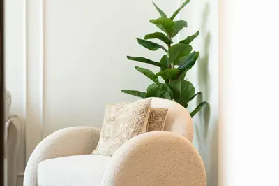 a chair with a pillow and a potted plant at Luxury 1BR Apartment - Pool View - The Crest Dubai in Dubai