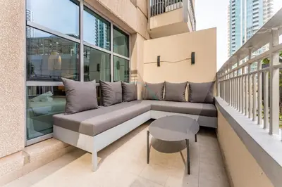 a balcony with a couch and a table on a building at Walk from Burj Khalifa and Dubai Mall, and Conveniently Located near the Metro Station - BD Standpoint A, Downtown by Deluxe Holiday Homes in Dubai