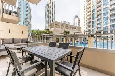a table and chairs on a balcony with buildings at Walk from Burj Khalifa and Dubai Mall, and Conveniently Located near the Metro Station - BD Standpoint A, Downtown by Deluxe Holiday Homes in Dubai