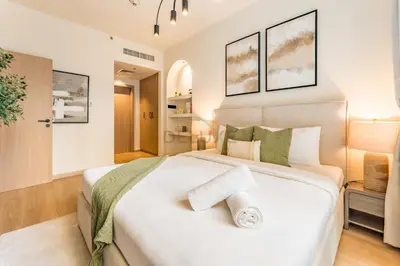 a bedroom with a large white bed with green pillows at Walk from Burj Khalifa and Dubai Mall, and Conveniently Located near the Metro Station - BD Standpoint A, Downtown by Deluxe Holiday Homes in Dubai
