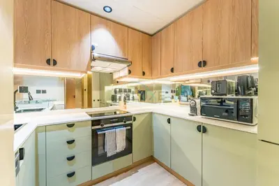a large kitchen with wooden cabinets and appliances at Walk from Burj Khalifa and Dubai Mall, and Conveniently Located near the Metro Station - BD Standpoint A, Downtown by Deluxe Holiday Homes in Dubai