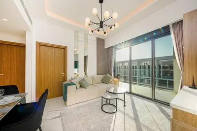 a living room with a couch and a large window at Cozy Apartment in Azizi Riviera - 10 min to Burj Khalifa in Dubai