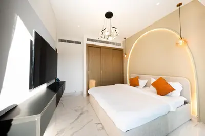 a bedroom with a large bed and a tv at Cozy Apartment in Azizi Riviera - 10 min to Burj Khalifa in Dubai