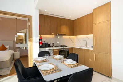 a kitchen and dining room with a table and chairs at Cozy Apartment in Azizi Riviera - 10 min to Burj Khalifa in Dubai