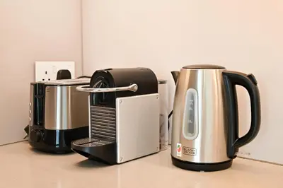 three coffins and a coffee maker on a counter at Brand New 1BD in Address JBR, Relaxing Stay for 2 in Dubai