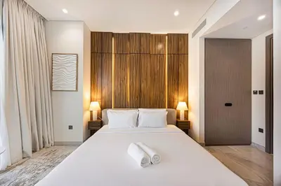 a bedroom with a large white bed with two towels on it at 833keys - 1BR - Waterfront Stay - Business Bay in Dubai