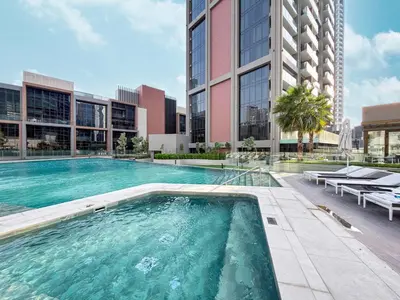 a swimming pool in front of a tall building at 833keys - 1BR - Waterfront Stay - Business Bay in Dubai