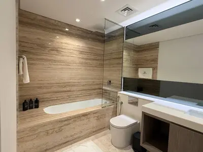 a bathroom with a tub and a toilet and a sink at Sterling West House in Dubai