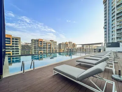 a balcony with a swimming pool on top of a building at Vogue Al Maktoum City Sobha Hartland Waves Near to Downtown, Burj Khalifa and Dubai Mall, One Bedroom Apartment plus Kids room with Balcony and City View, Access to all Amenities in Dubai