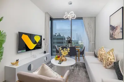 a living room with a couch and a table at Vogue Al Maktoum City Sobha Hartland Waves Near to Downtown, Burj Khalifa and Dubai Mall, One Bedroom Apartment plus Kids room with Balcony and City View, Access to all Amenities in Dubai
