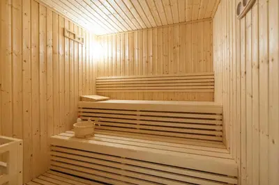 a wooden sauna with a tub in a room at Vogue Al Maktoum City Sobha Hartland Waves Near to Downtown, Burj Khalifa and Dubai Mall, One Bedroom Apartment plus Kids room with Balcony and City View, Access to all Amenities in Dubai