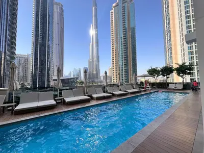 a swimming pool with lounge chairs and a city skyline at Act Tower 410 in Dubai
