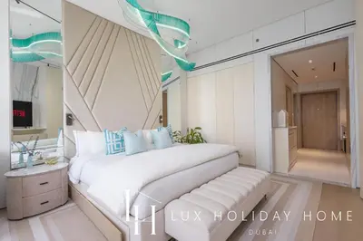 a bedroom with a large white bed with blue pillows at LUX Iconic Views at The Palm Tower Studio 4 in Dubai