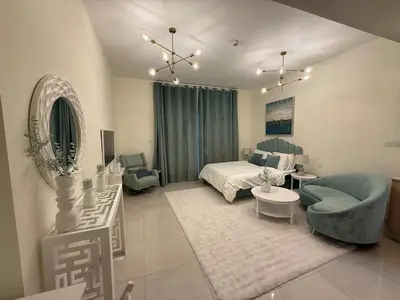 a living room with a bed and a couch and a table at Canal View Studio AG Tower in Dubai