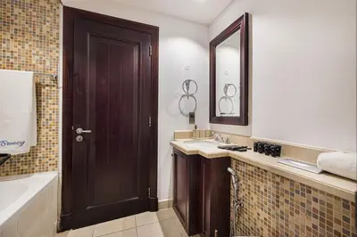 a bathroom with a sink and a mirror and a tub at Luxury Old Town Yansson Downtown Dubai Apartment Pool Burj Khalifa Views Steps to Dubai Mall by La Brisa in Dubai
