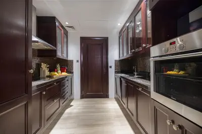 a large kitchen with wooden cabinets and stainless steel appliances at Luxury Old Town Yansson Downtown Dubai Apartment Pool Burj Khalifa Views Steps to Dubai Mall by La Brisa in Dubai