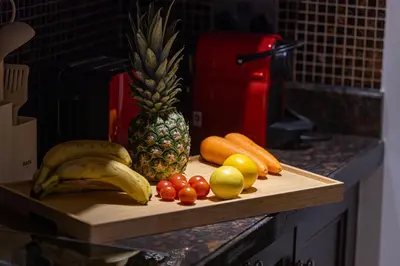 a cutting board with fruit and vegetables on a counter at Luxury Old Town Yansson Downtown Dubai Apartment Pool Burj Khalifa Views Steps to Dubai Mall by La Brisa in Dubai