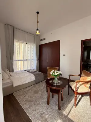 a bedroom with a bed and a table and a couch at Lux 4BR JBR I Sea View I Walk to Beach I Sleeps 12 in Dubai