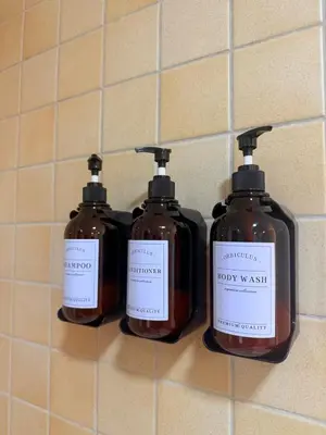 three bottles of soap are on a wall at Lux 4BR JBR I Sea View I Walk to Beach I Sleeps 12 in Dubai